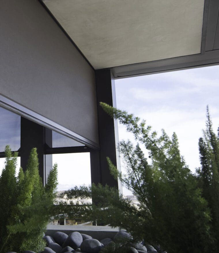 Modern home exterior with retractable screens on large windows